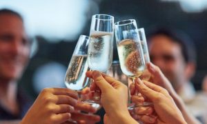 a group of people celebrating by cheering their champagne glasses