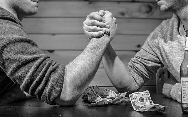 Friends betting arm wrestling