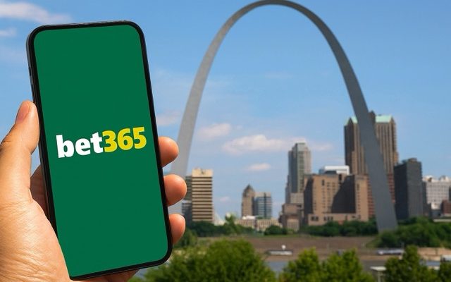 A hand holds a smartphone displaying the bet365 logo with the St. Louis Gateway Arch and downtown skyline in the background.