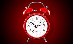 Bright Red Alarm Clock with White Face On Gradient Background