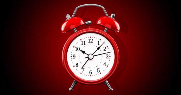 Bright Red Alarm Clock with White Face On Gradient Background