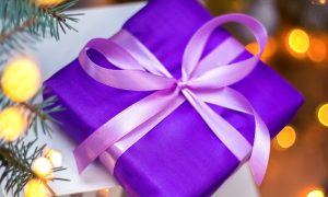 Close Up of Purple Wrapped Christmas Gift with Ribbon