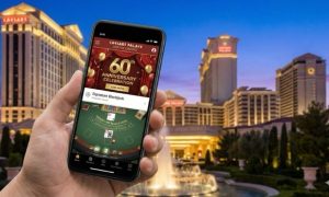 A hand holding a smartphone displaying the Caesars Palace Online Casino 60th Anniversary banner and a "Signature Blackjack" table in front of the illuminated Caesars Palace Las Vegas resort at twilight.