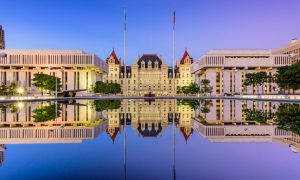 The New York State Capitol Building At Dusk is reflected in water Creating a Mirror Image