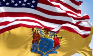 Close Up Image of Waving American Flag Above NJ State Flag Against Blue Sky