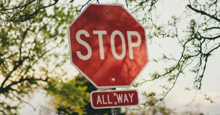 White Sky with Trees Background to Red Stop Sign on the Road