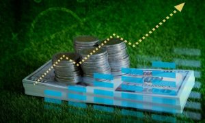 Financial Graph Digital Overlay on Stacks of Coins and Bills on Green Grass