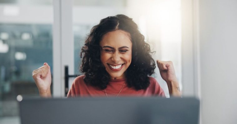 Happy Woman Sits in Front of Laptop