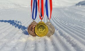 Gold, Silver and Bronze Olympic Metals Hang On Ribbons On Snowy Hill