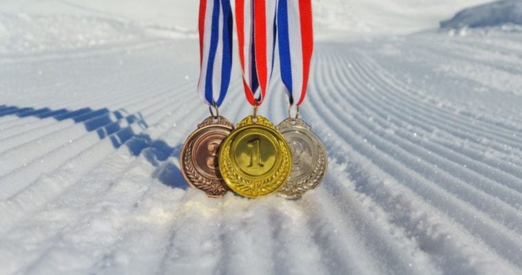Gold, Silver and Bronze Olympic Metals Hang On Ribbons On Snowy Hill