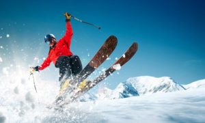 Man Jumping on Skiis From a Snowy Mountain Top