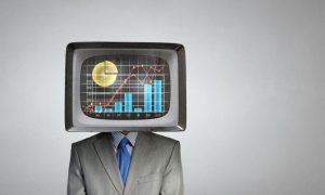 Man Wearing Suit Has TV Displaying Bar and Line Graphs Instead of Head
