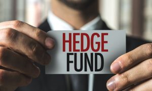Card Reading Hedge Fund Held by Man in Black Suit