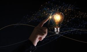 Edison Bulb Glows With Sparkles Flying Around and Man's Finger Toucing it