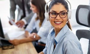 Attractive Young Woman Works As Call Center Agent Using White Headphones