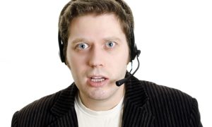 Man In Sports Jacket Wears Headset and Confused Look On Face