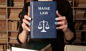 Woman Inside Library Holds Legal Blue Book Saying Maine Law