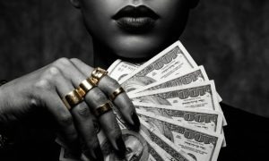 Black & White Image of Woman Holding Fan of Hundreds USD