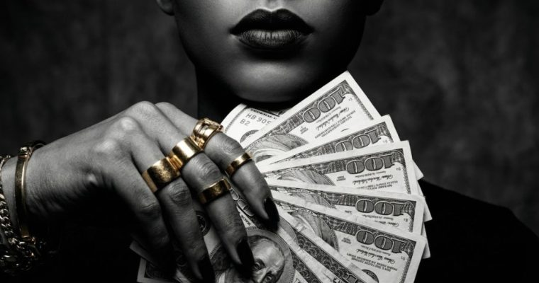 Black & White Image of Woman Holding Fan of Hundreds USD