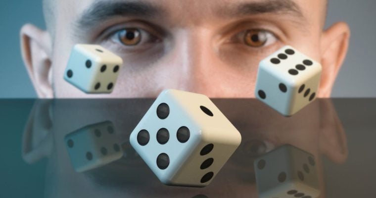 Close Up of Man's Brown Eyes Watching Three Dice Tumbling on Table