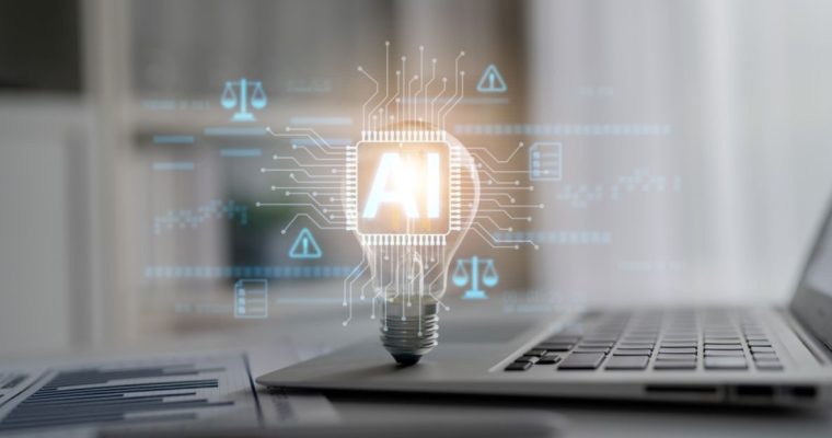 Silver Laptop, Light Bulb With AI Computer Circuit and Paper with Bar Graph Sit on Desk