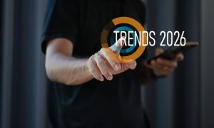 Man in Black T-Shirt Points to Screen With Yellow and Blue Loading Circle and Trends 2026 Text