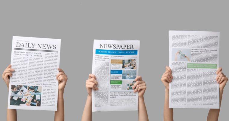 Three Hands Hold Newspapers Up Above Heads on Solid Gray Background