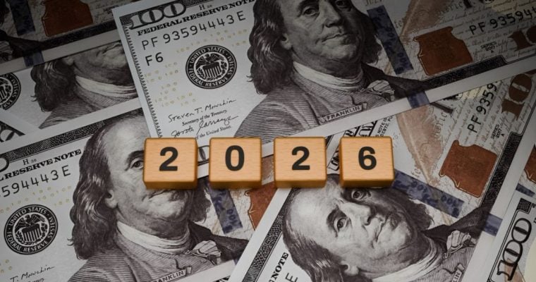 $100 Banknotes Layed On Table with Wooden Blocks Spelling 2026 on Top