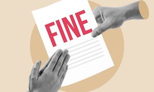 Hand Holds White Paper With Fine in Red Letters and Hands Praying