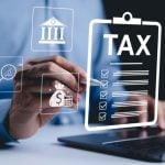 Digital Icons Representing Taxes and Finances Overlay Image of Man on Laptop Pointing with Pen
