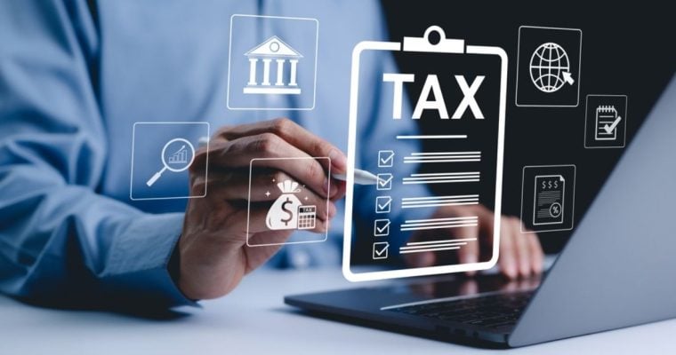 Digital Icons Representing Taxes and Finances Overlay Image of Man on Laptop Pointing with Pen