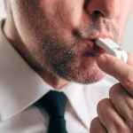 Man in White Shirt and Black Tie Blows White Whistle