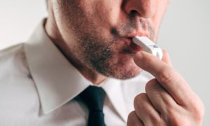 Man in White Shirt and Black Tie Blows White Whistle
