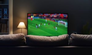 Soccer Game Plays on TV In Front of Empty Couch Inside Living Room