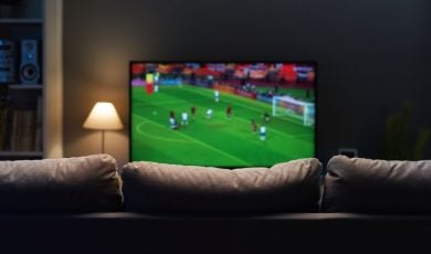 Soccer Game Plays on TV In Front of Empty Couch Inside Living Room