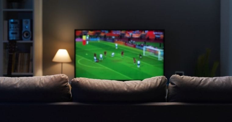 Soccer Game Plays on TV In Front of Empty Couch Inside Living Room