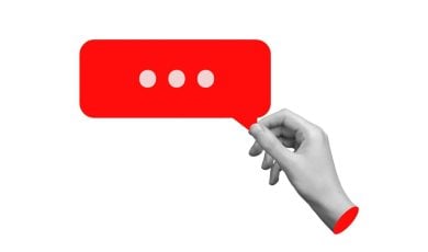 Art Collage of Isolated Black-White Hand Holding a Red Speech Bubble