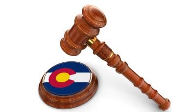 Colorado Flag Printed on Base of Judge's Wooden Mallet With Gavel Hovering Above