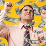 Cash Flies Around Excited Man With Fisted Hands Wearing Pink Button Down Shirt and Tie