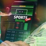 Man Uses Mobile Phone for Live Online Sports Betting on Soccer with Cash