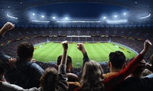Soccer Stadium Filled With Cheering Fans Watching Nighttime Game Inside Stadium
