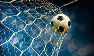 Blue and White Skies Background to Close Up Image of Soccer Ball Hitting Back of Net