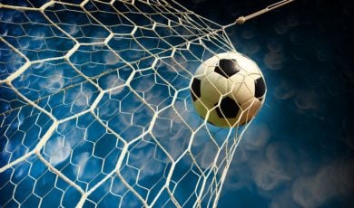 Blue and White Skies Background to Close Up Image of Soccer Ball Hitting Back of Net