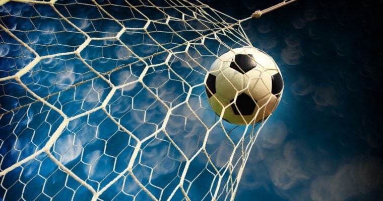 Blue and White Skies Background to Close Up Image of Soccer Ball Hitting Back of Net