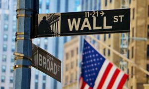 NYC Buildings and American Flag Hangs in the Background of Wall Street Sign