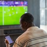 Man Uses Mobile Phone for In-Game Sports Betting In Living Room