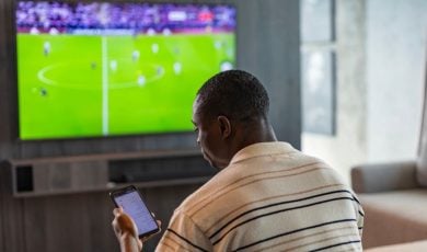 Man Uses Mobile Phone for In-Game Sports Betting In Living Room