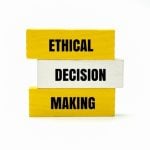 Yellow Wooden Blocks Say Ethical Making and One White Block Says Decision in the Middle