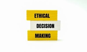 Yellow Wooden Blocks Say Ethical Making and One White Block Says Decision in the Middle