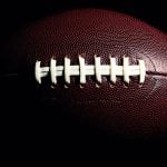 Close-Up Photo of Textured Brown American Football with White Stitching